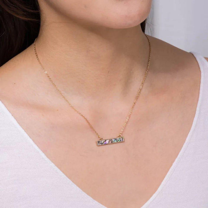 Gold chain necklace with small rectangular abalone shell pendant in teal and purple tones