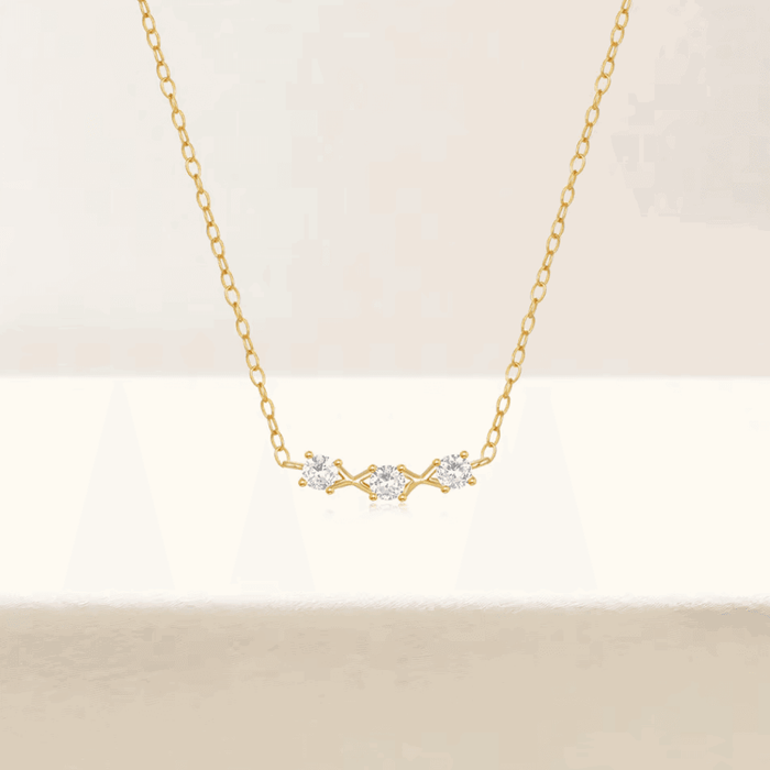 Gold-tone necklace with three small round cubic zirconia stones at center