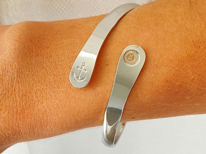 Silver anchor cuff bracelet on wrist with oval charm plate detail