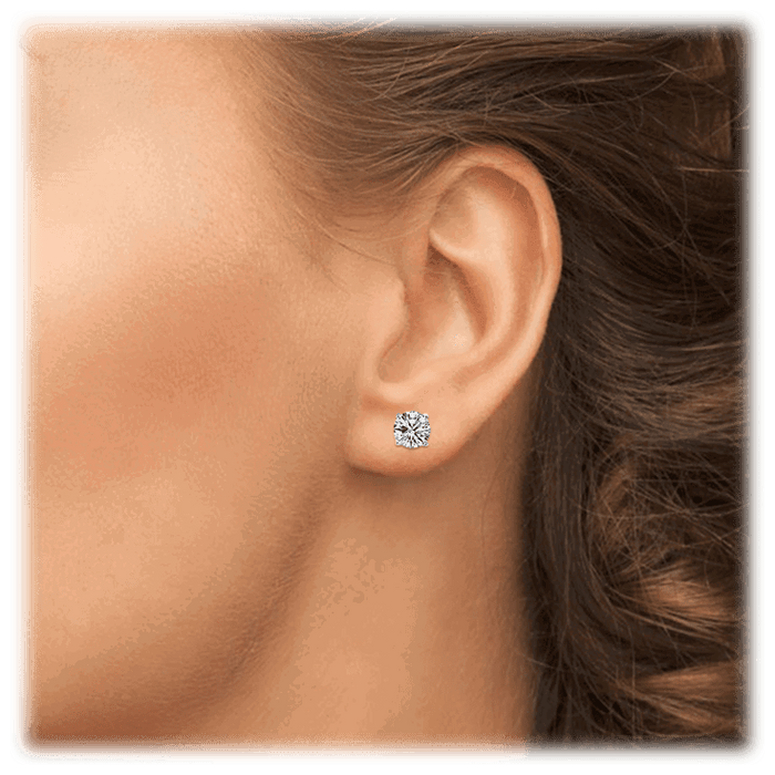 Small round cubic zirconia stud earrings on ear, silver-tone setting