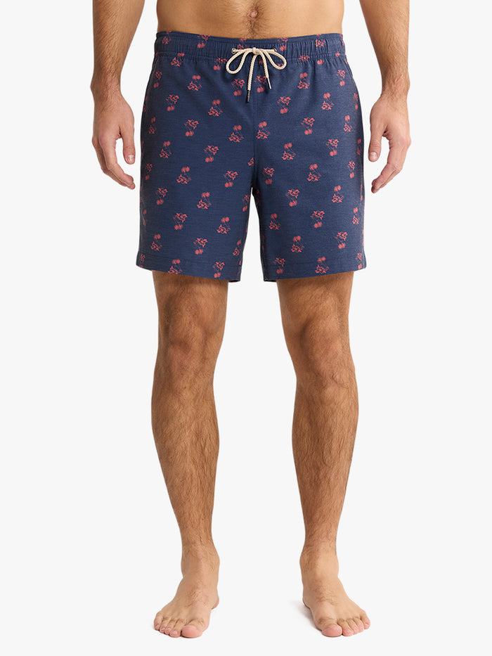 Navy swim shorts with red pattern worn by a person on a white background