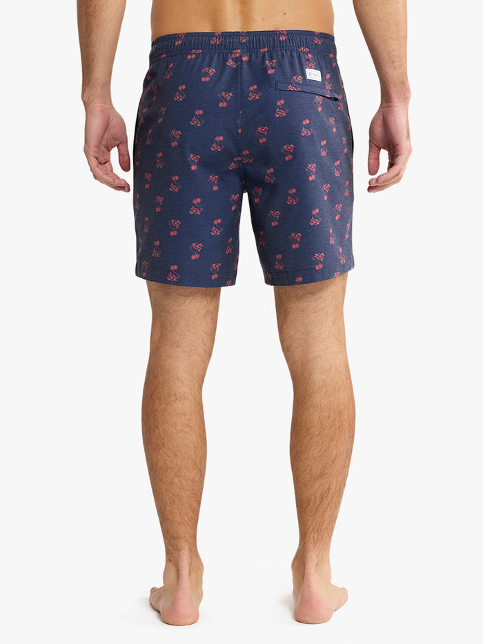 Navy swim shorts with red pattern worn by a person on a white background