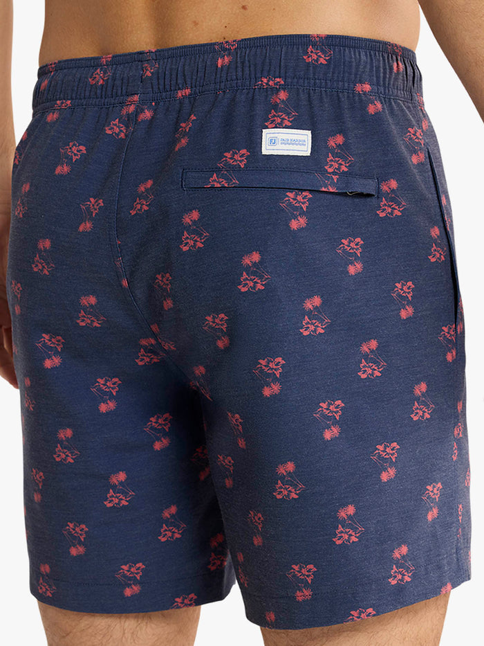 Navy blue shorts with red floral pattern worn by a person on a white background