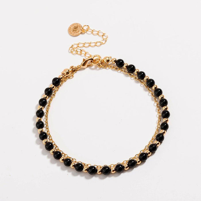 Gold beaded friendship bracelet with black beads and extended chain clasp