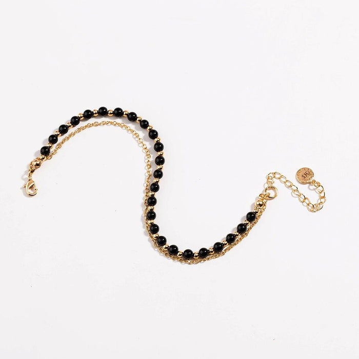 Gold beaded friendship bracelet with black beads and lobster-style clasp