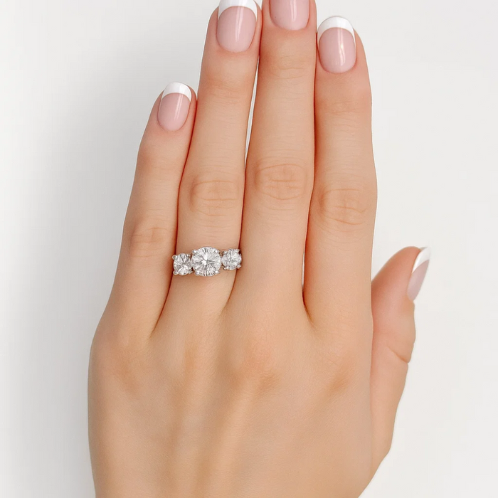 Three-stone cubic zirconia ring on hand, rose-gold tone band with clear round stones