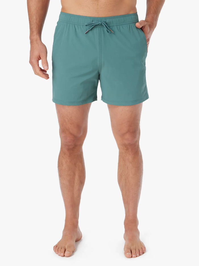Person wearing solid seapine green bungalow trunk with drawstring on a white background.