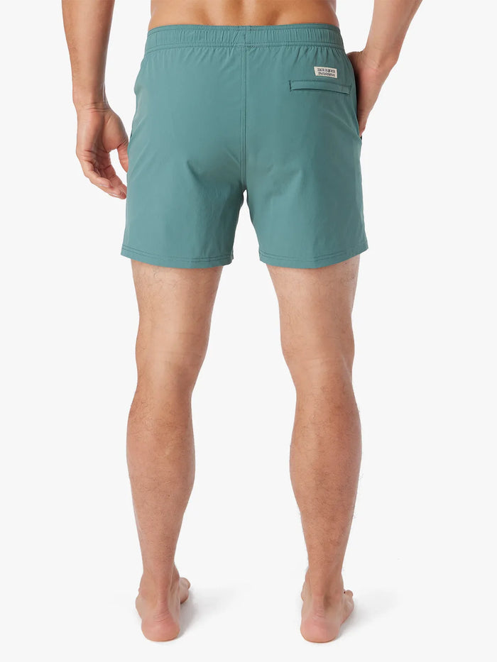 Person wearing solid seapine green bungalow trunk on a white background. Showing the back view.