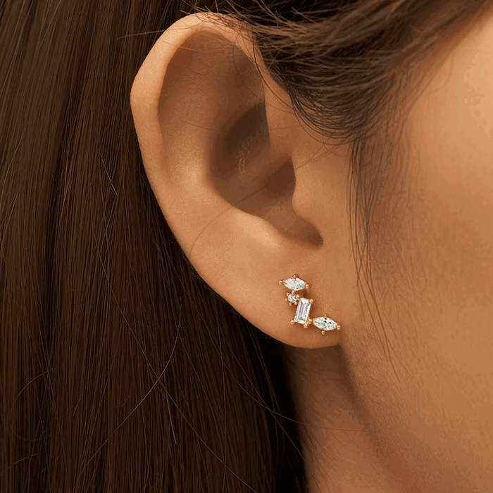Silver-tone celestial cluster CZ earrings on ear, featuring oval and baguette stones