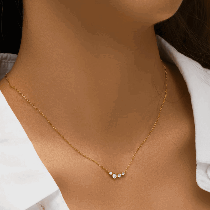 Gold-tone chain necklace with three clear stones in a small dangling cluster