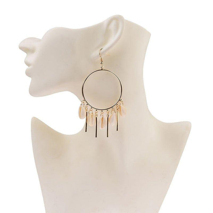 Gold hoop chandelier earrings with peach puka seashell fringe on mannequin bust