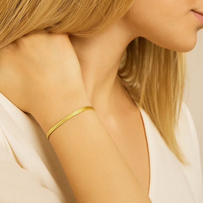 Gold-tone snake chain bracelet on arm with minimalist adjustable clasp