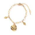 Gold coin charm bracelet with coin pendant, leaf charms, and linked chain