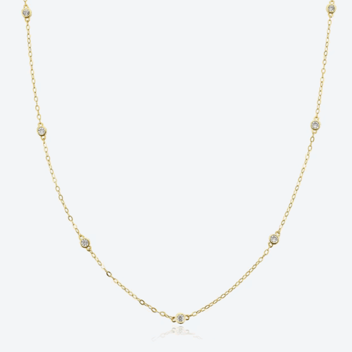Gold-tone dainty necklace with round cubic zirconia halo bezel accents along chain