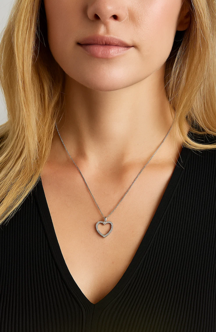Heart pendant necklace with cubic zirconia stones, silver-tone chain on model
