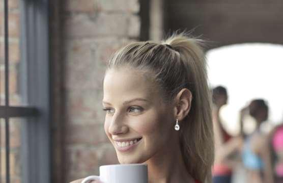 Woman wearing silver teardrop crystal earrings with small hoop top
