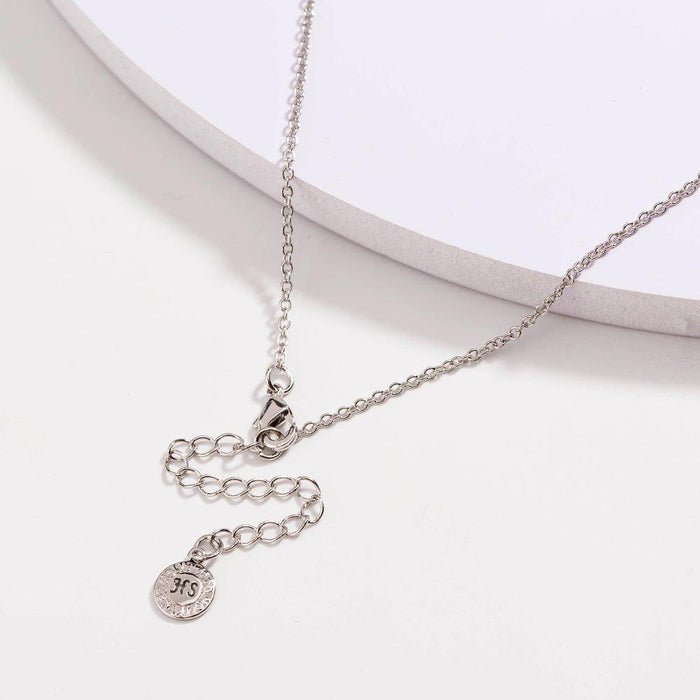 Silver link necklace with black bead accents and round charm on extender