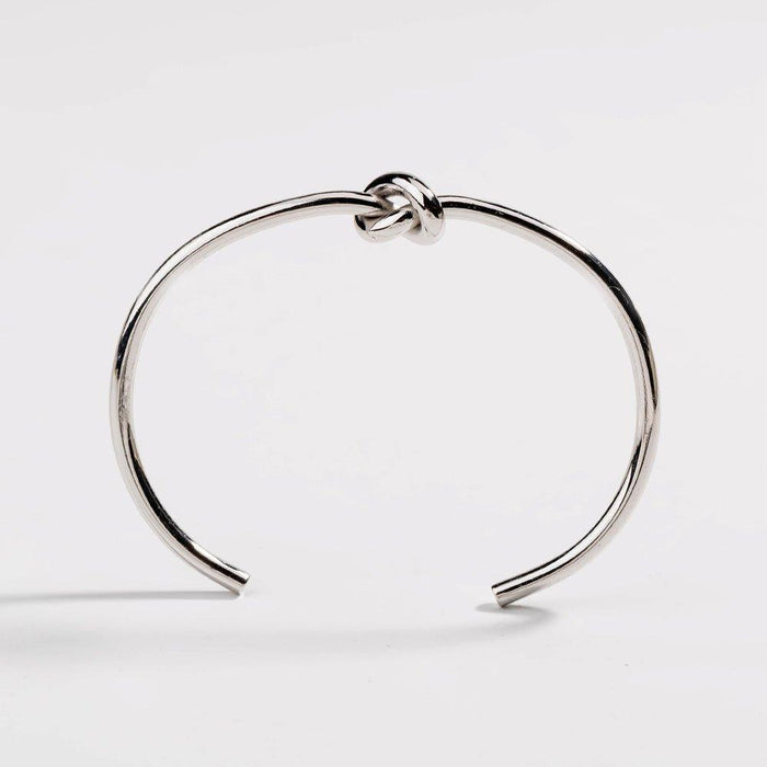 Silver love-knot bracelet with twisted knot clasp on a slim round bangle