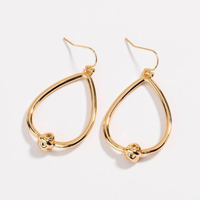 Gold teardrop hoop earrings with love-knot charm at the bottom