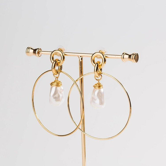 Gold-tone drop hoop earrings with simulated pearl teardrop charms, front view