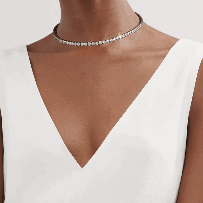 Silver cubic zirconia choker necklace worn at the collarbone, tight stone row