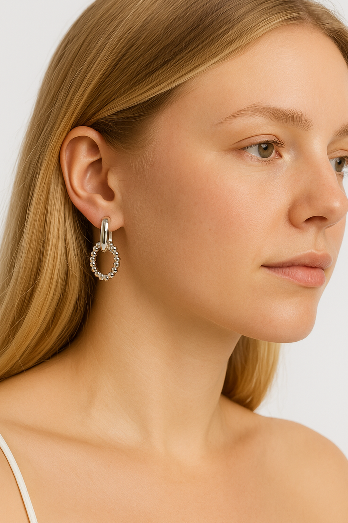 Gold link drop earrings with small beaded oval ring and heart-like open center.