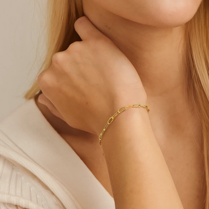 Gold paperclip link bracelet on wrist with delicate chain links