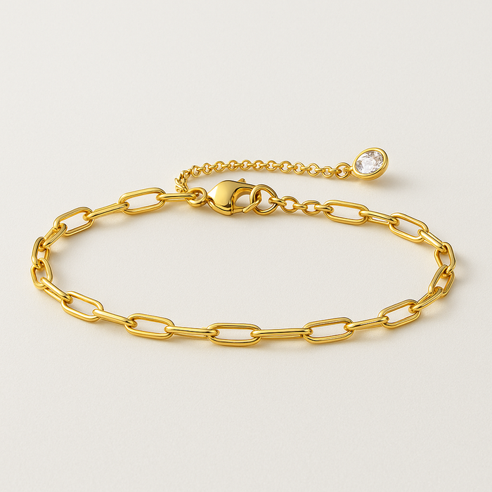 Gold paperclip link bracelet with round stone detail and clasp, laid flat