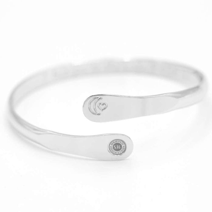 Silver moon and heart cuff bracelet with central oval detail and round charm plate