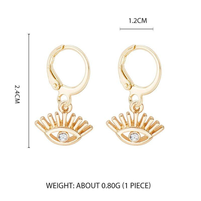 Gold-tone huggie hoop earrings with evil-eye charm and small blue crystal