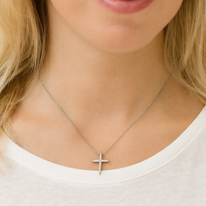 Cubic zirconia cross pendant necklace worn on a neckline