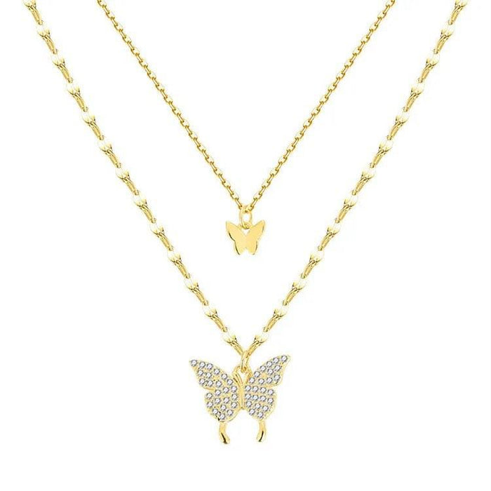 Two-layer gold butterfly necklace with small central charm and larger bottom butterfly pendant