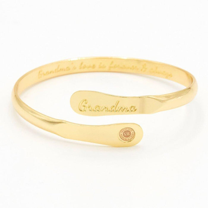 Gold-toned cuff bracelet with engraved “Grandma” and round charm detail