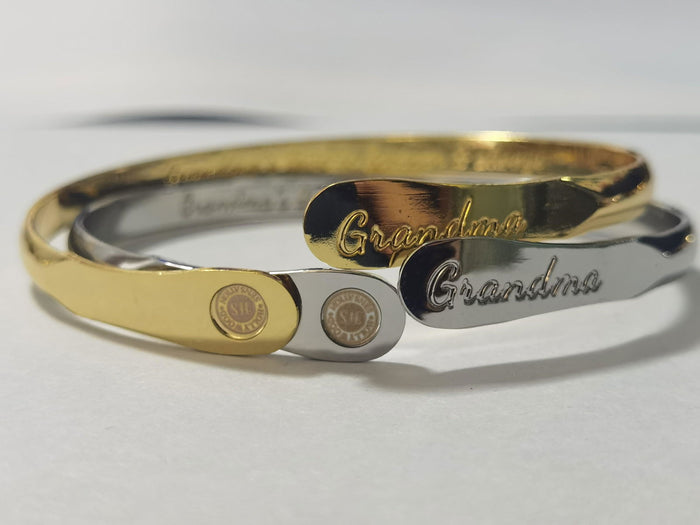 Two-tone gold and silver cuff bracelet with engraved “Grandma” and charm inserts