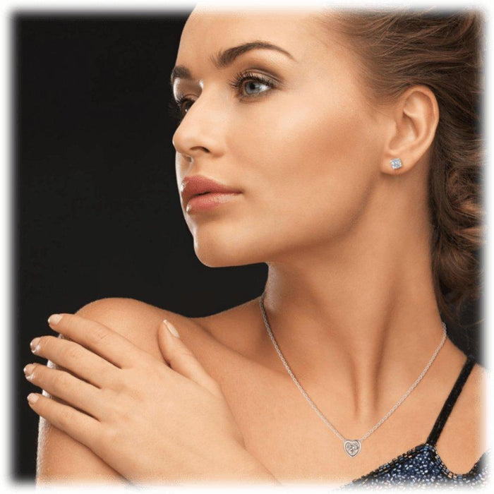 Silver-tone heart pendant necklace with clear cubic zirconia crystal, close-up on neck