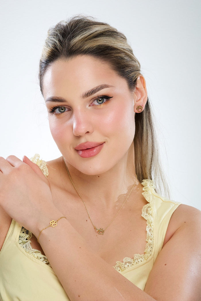 Gold heart and paw pendant necklace on thin chain, close-up on model