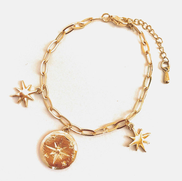 Gold-tone link charm bracelet with round locket and star charms, dangling details