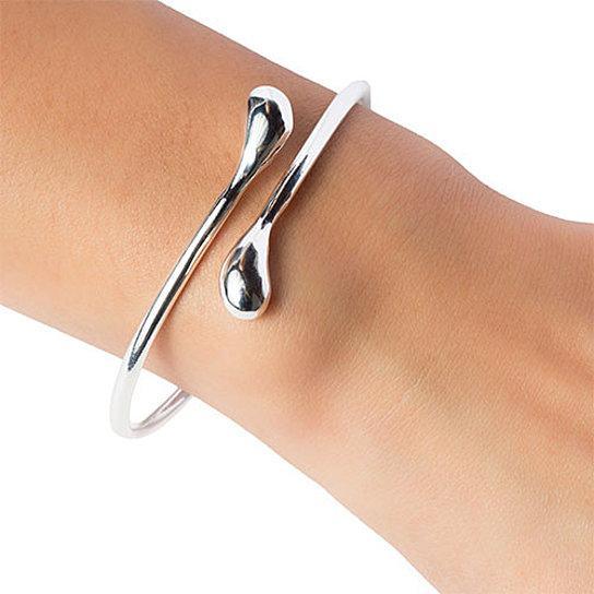 Silver teardrop open wrap bangle bracelet on wrist with curved open teardrop