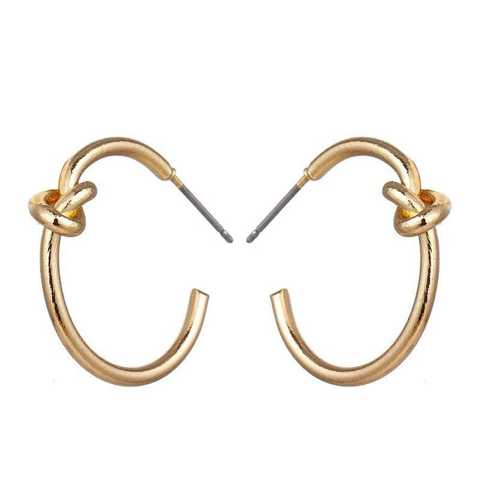 Gold knot hoop earrings with twisted knot at top of each rounded hoop
