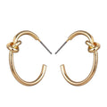 Gold knot hoop earrings with twisted knot at top of each rounded hoop