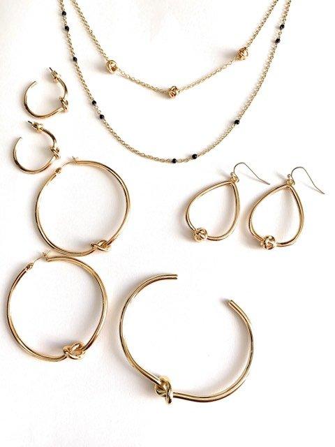 Gold hoop earrings set with twisted knot accents on round hoops