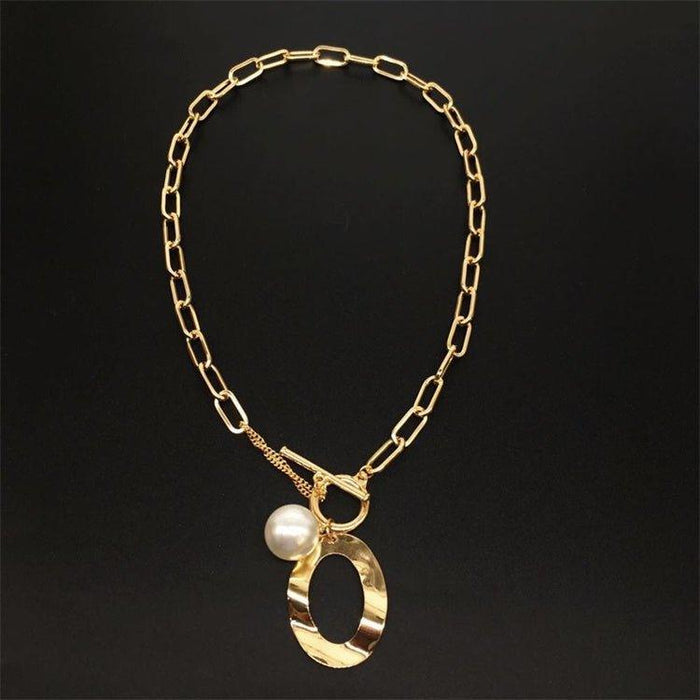 Gold link necklace with oval pendant, faux pearl, and center toggle ring