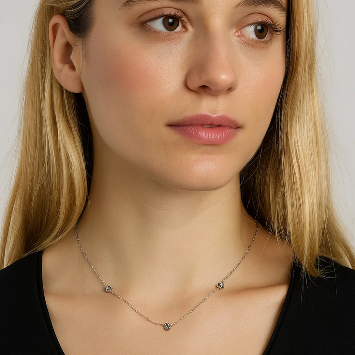 Silver-tone chain necklace with small love-knot charm at center