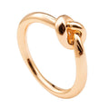 Gold love knot commitment ring with dark center stone, high-shine band