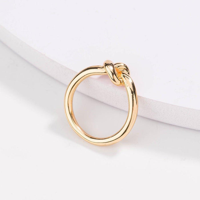 Gold love knot commitment ring with sculpted knot top, polished finish