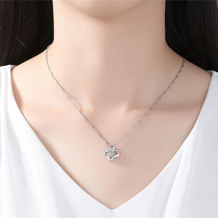 Love knot stud earrings paired with crystal pendant necklace at neckline