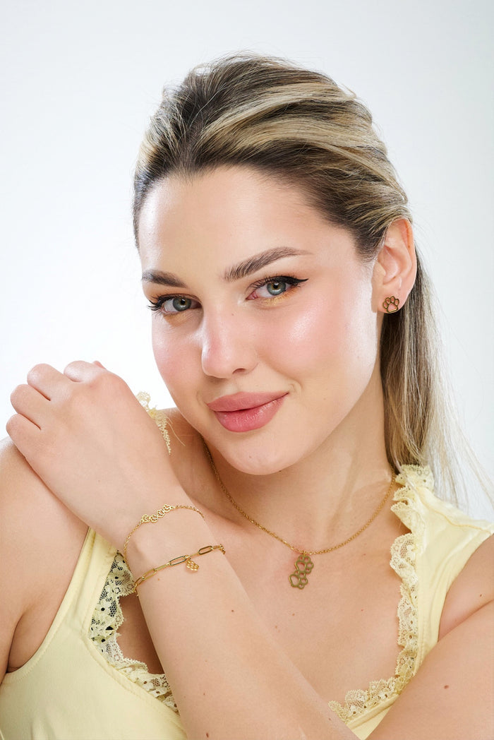 Gold paw print link bracelet with small paw charms, worn on wrist