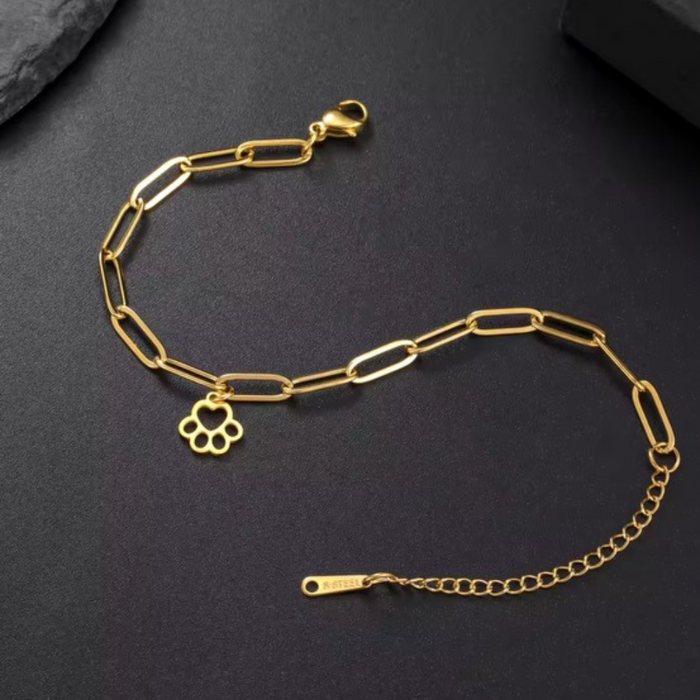 Gold link bracelet with paw-print charm, chain links, and clasp detail