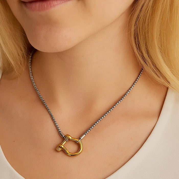 Silver carabiner pendant necklace worn close-up with horseshoe-style charm