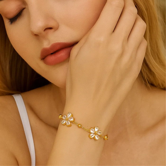 Gold-tone bracelet with crystal flower charm details and small bead accents